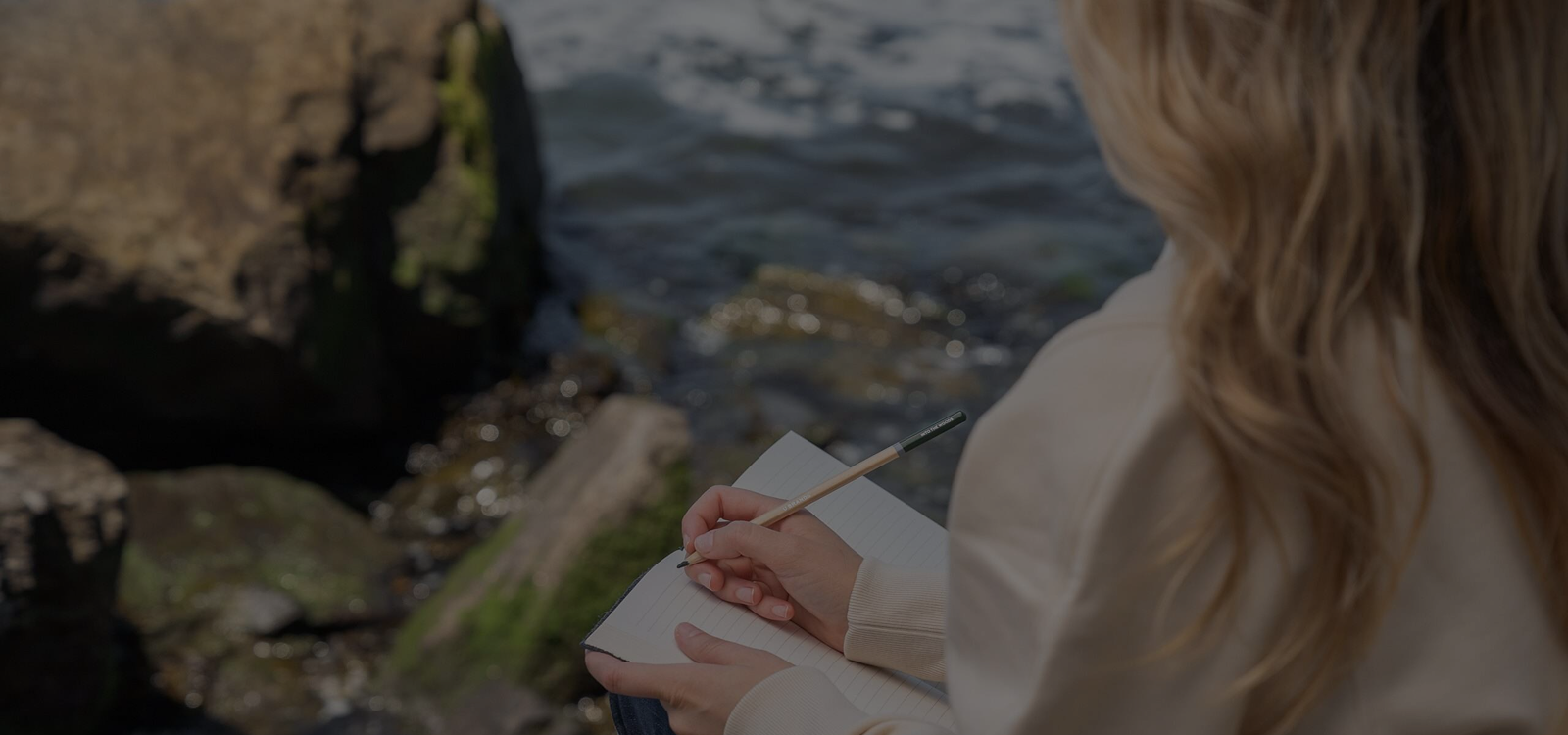 Woman sitting by the ocean