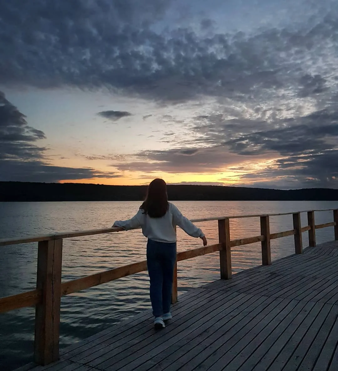 Woman on dock watching sunset